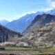 A green valley framed by snow mountains in Gilgit-Baltistan