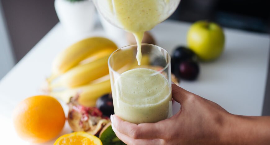 A fruit smoothie being poured into a glass
