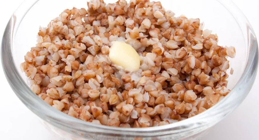 A bowl of cooked buckwheat groats (kasha) topped with a pat of melting butter