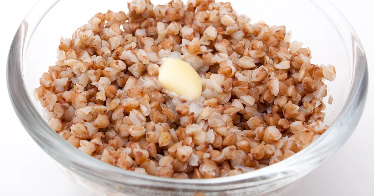 A bowl of cooked buckwheat groats (kasha) topped with a pat of melting butter
